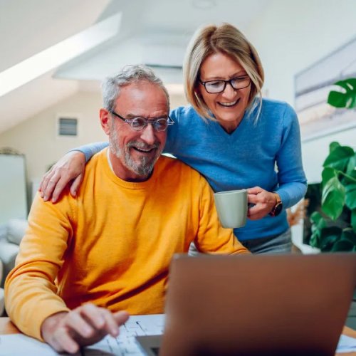 older couple looking at their laptop laughing